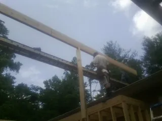 Carpenter setting a ridge beam over a new addition frame — Ice Dam Removal by Roofing Brothers in Hollis Center