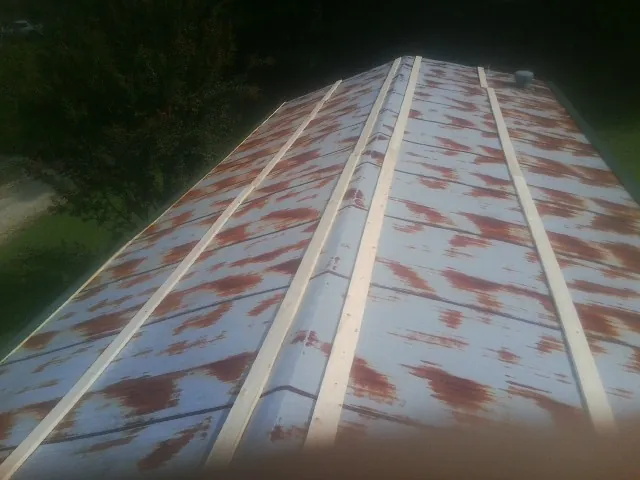 Rusted metal roof panels with new wood purlins before replacement — Storm Damage Roof Repair in Hollis Center by Roofing Brothers