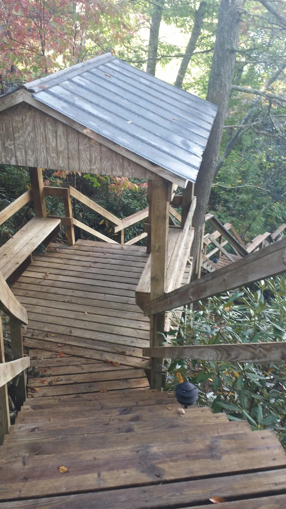 Metal roofed shelter over wooden steps on a wooded walkway — Skylight Repair & Installation work by our crew in Hollis Center